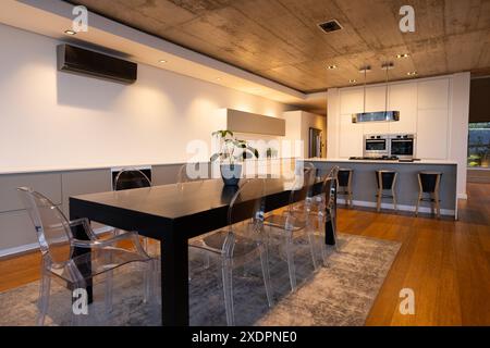 Grande table à manger et chaises transparentes, cuisine moderne au design épuré Banque D'Images