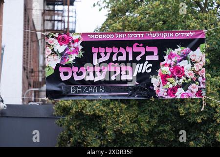 Une bannière yiddish colorée à Williamsburg annonçant que les Satmar Ladies Auxiliary vendraient des fleurs et des plantes en préparation de Shavouot Banque D'Images