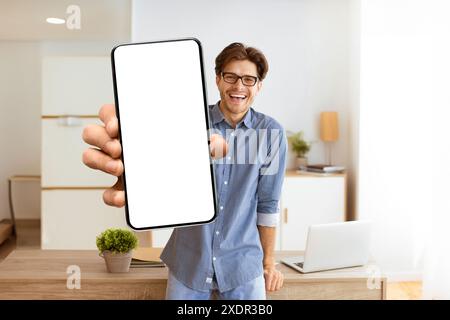 Homme tenant smartphone avec écran vide dans le bureau Banque D'Images