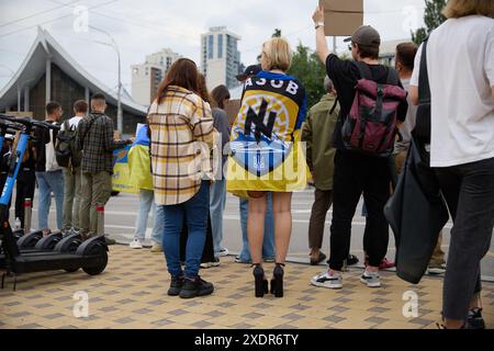 Fille ukrainienne portant un drapeau de la brigade Azov sur ses épaules lors d'une manifestation pacifique en Ukraine. Kiev - 16 juin 2024 Banque D'Images