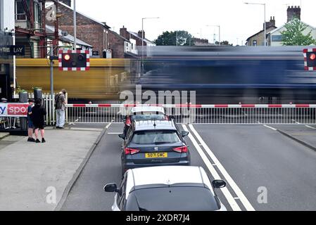 Autour du Royaume-Uni - train de fret qui accélère à travers les passages à niveau à Bamber Bridge, Lancashire, Royaume-Uni Banque D'Images