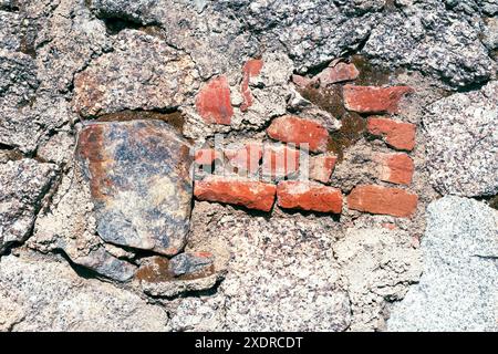 Texture de vieux mur de maison en pierres de granit et briques rouges. Banque D'Images