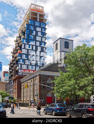 NYC Chinatown : 59 Henry Street, en construction, domine les voisins ; ses panneaux de verre et de métal se heurtent à une église de maçonnerie vieille de 200 ans. Banque D'Images