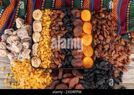 Types de fruits secs. Abricots séchés, raisins secs noirs et légers et figues séchées dans un sac cadeau. Il existe de nombreux types de fruits secs en piles sur le coun Banque D'Images