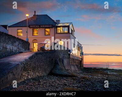 Le soleil descend lentement vers l'horizon à la veille du solstice d'été alors que le Royal George illumine le quai d'Appledore dans le nord du Devon, en Angleterre Banque D'Images