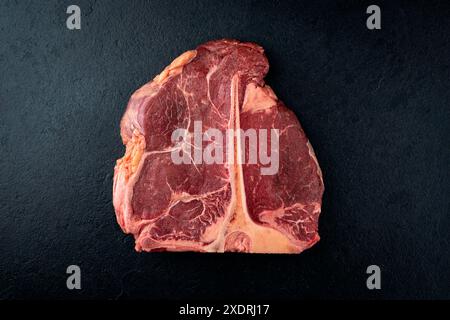 Steak de bœuf chianina vieilli cru et sec offert comme vue de dessus sur un tableau noir Banque D'Images