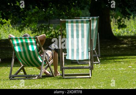 Les membres du public apprécient le soleil d'été à Green Park à Londres. Des sommets allant jusqu'à 31 °C ont été prévus pour cette semaine alors que les températures continuent d'augmenter dans tout le Royaume-Uni. Date de la photo : lundi 24 juin 2024. Banque D'Images