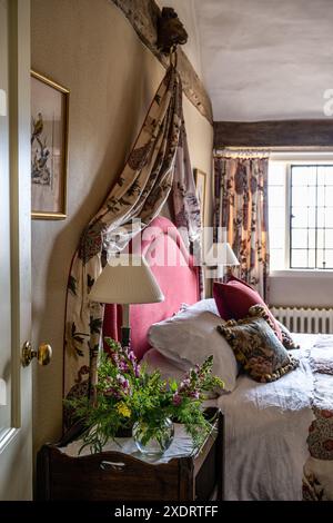 Cabinet William IV avec plateau-dessus avec tissus vintage dans la chambre de la ferme Tudor du 16ème siècle, Hertfordshire, Angleterre, Royaume-Uni. Banque D'Images