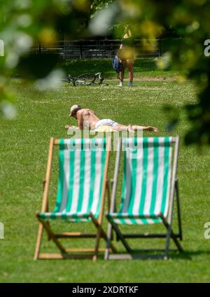 Les membres du public apprécient le soleil d'été à Green Park à Londres. Des sommets allant jusqu'à 31 °C ont été prévus pour cette semaine alors que les températures continuent d'augmenter dans tout le Royaume-Uni. Date de la photo : lundi 24 juin 2024. Banque D'Images