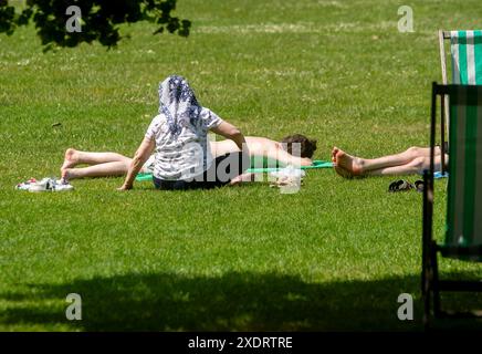 Les membres du public apprécient le soleil d'été à Green Park à Londres. Des sommets allant jusqu'à 31 °C ont été prévus pour cette semaine alors que les températures continuent d'augmenter dans tout le Royaume-Uni. Date de la photo : lundi 24 juin 2024. Banque D'Images