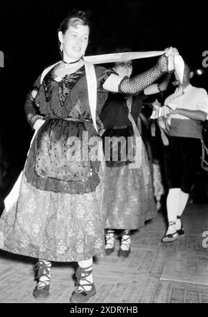 Männer und Frauen in traditioneller Kleidung führen einen Volkstanz auf der Festa major, dem größten Volksfest in San Felíu de Guixols, auf, Katalonien 1957. Hommes et femmes en tenue traditionnelle jouent une danse folklorique à la Festa Major, le plus grand festival folklorique de San Felíu de Guixols, Catalogne 1957. Banque D'Images