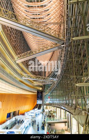 Vue verticale grand angle le long de l'intérieur du bâtiment du Forum international de Tokyo dans la soirée, montrant l'étage principal et le toit au-dessus. Banque D'Images