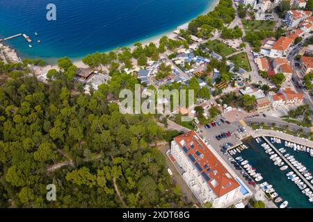 Vue plongeante sur la côte courbe et la ville de Makarska. Croatie. Bateaux dans le port, forêts vertes, Banque D'Images