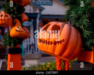 Tête Halloween Jack o Lantern Pumpkins avec le visage souriant effrayant suspension décoration en face de la maison dans le petit village. Couleur orange de citrouille Banque D'Images