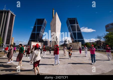 Groupe de personnes dansant devant le monument du sculpteur Jose Calvo Sotelo avec en arrière-plan les tours Kio Banque D'Images