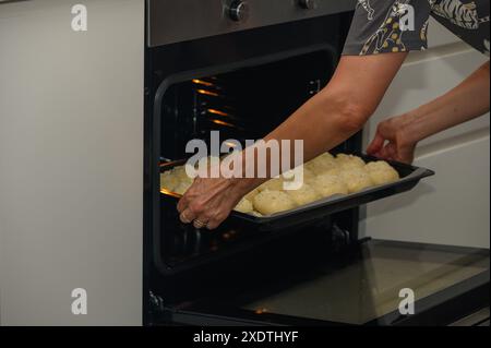 femme met les petits pains au four sur une plaque de cuisson 2 Banque D'Images