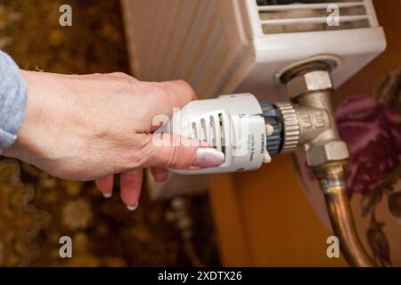 Réglage manuel de la température sur le thermostat du radiateur de chauffage, concept économique. Tourner le bouton du radiateur de chauffage pour contrôler la chaleur dans la maison. Augmentant ou diminuant Banque D'Images