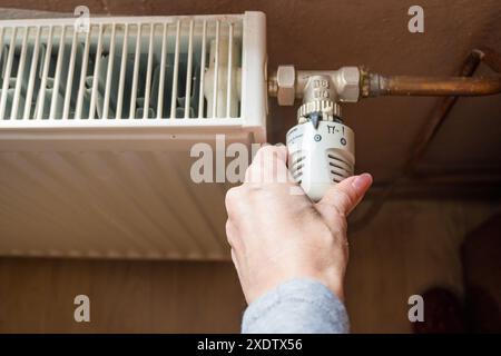 Réglage manuel de la température sur le thermostat du radiateur de chauffage, concept économique. Tourner le bouton du radiateur de chauffage pour contrôler la chaleur dans la maison. Augmentant ou diminuant Banque D'Images