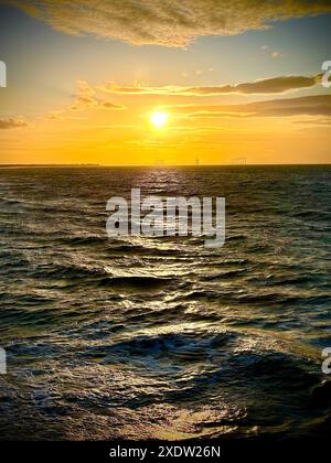 Coucher de soleil sur la côte nord-est, avec l'estuaire de Tees et le parc éolien offshore de Teesside au loin. Crédit : James Hind/Alamy. Banque D'Images