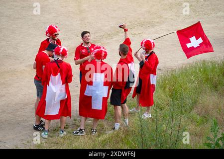 Les fans suisses en tenue rouge, arborant fièrement des symboles et drapeaux nationaux, attendent le match de l'UEFA EURO 2024, Francfort, Allemagne – 23 juin 2024 Banque D'Images