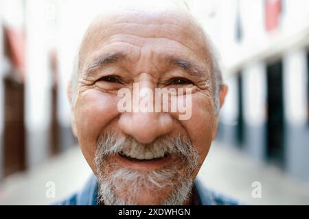Heureux homme senior regardant la caméra avec la ville sur fond. Concept de communauté ancienne d'amérique latine Banque D'Images