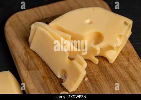 fromage à la crème avec des trous sur la table, fromage à pâte dure sur la table Banque D'Images