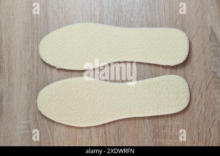 Semelles intérieures en peau de mouton blanche naturelle offrant chaleur et confort pour les pieds, idéales pour les chaussures d'hiver, douceur et soutien Banque D'Images