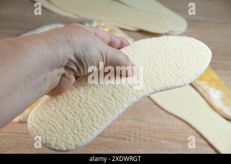 Semelles intérieures en peau de mouton blanche naturelle offrant chaleur et confort pour les pieds, idéales pour les chaussures d'hiver, douceur et soutien Banque D'Images