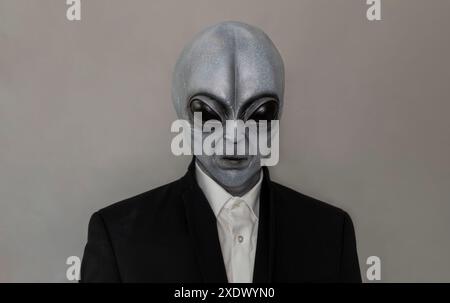 Portrait d'Alien portant costume fond gris. Journée mondiale des OVNIS. Être extra terrestre, objets volants non identifiés. Plan vertical. Humanoïde gris. Banque D'Images