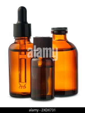 Trois bouteilles en verre ambré avec Dropper Tops sur fond blanc Banque D'Images