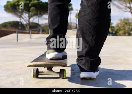 Skateboard au parc, étudiant masculin en équilibre sur le skateboard, profiter de l'activité de plein air Banque D'Images