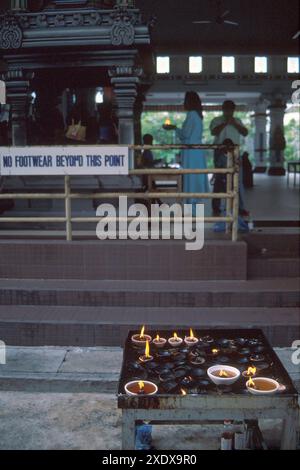 Bougies et femme tenant la flamme en arrière-plan pour la cérémonie Deepavali, temple Sri Mariamman, Little India, Singapour Banque D'Images