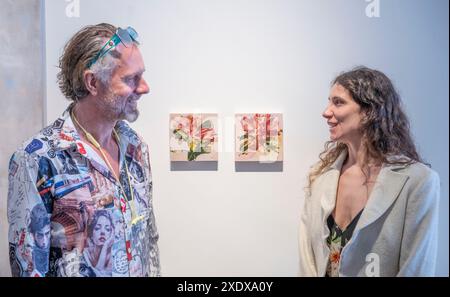 Flowers Gallery, Cork Street, Londres, Royaume-Uni. 24 juin 2024. L’exposition artiste du jour présente une nouvelle génération d’artistes qui ont été choisis par des artistes de renom, à commencer par Bianca Raffaella choisie par Dame Tracey Emin DBE RA. Artiste multidisciplinaire Bianca Raffaella est une artiste aveugle enregistrée, designer, activiste et conférencière publique. Elle vise à démontrer aux personnes voyantes que la déficience visuelle n'est pas une restriction à être un artiste. Image : Bianca Raffaella discute ici de son travail avec un visiteur de l'exposition. Crédit : Malcolm Park/Alamy Banque D'Images