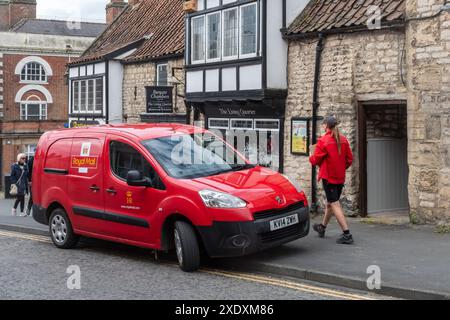 Postwoman et Red Royal mail van livrant le courrier dans le centre-ville de Pickering, North Yorkshire, Angleterre, Royaume-Uni Banque D'Images