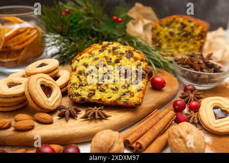 Gâteau de Noël traditionnel avec des raisins secs et des fruits sur fond en bois et blanc. Pain traditionnel aux fruits sucrés. Gâteau fait maison. Banque D'Images