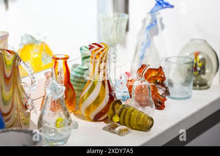 Verres et vases d'artisanat colorés sont sur un rebord de fenêtre, photo en gros plan avec mise au point sélective Banque D'Images