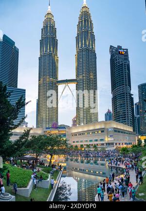 Kuala Lumpur, Malaisie-23 avril 2024 : comme la soirée approche dans le parc KLCC, à l'esplanade à l'extérieur du centre commercial Suria KLCC, de nombreux visiteurs anticipent t Banque D'Images