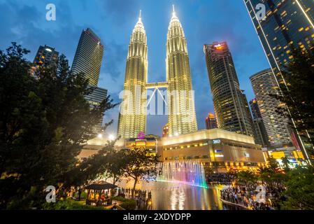 Kuala Lumpur, Malaisie-23 avril 2024 : comme la soirée approche dans le parc KLCC, à l'esplanade à l'extérieur du centre commercial Suria KLCC, de nombreux visiteurs anticipent t Banque D'Images