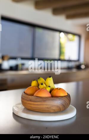 Bol d'oranges fraîches et de bananes sur le comptoir de cuisine dans la maison moderne, espace de copie Banque D'Images