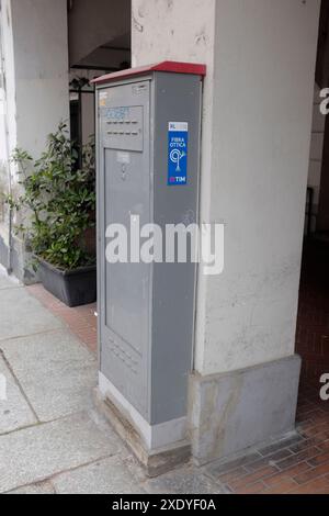 Cremona, Italie - 15 juin 2024 armoire de données à fibre optique en métal gris positionnée à côté d'un pilier en béton sur un trottoir de Tim Italie Banque D'Images