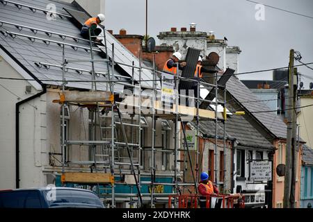 Ouvriers installant des panneaux solaires sur un toit à Ardara, comté de Donegal, Irlande. Banque D'Images