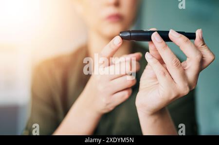 Mains, femme et. stylo de sucre de sang pour le diabète, les tests de santé et surveiller le glucose. Gros plan, personne et fille poke le doigt avec l'aiguille pour vérifier Banque D'Images