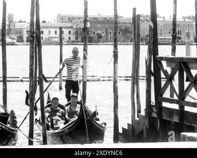 Venise, Italie - 30 juin 20220 image en noir et blanc d'un gondolier attendant les touristes pour monter à bord de sa télécabine à venise, italie Banque D'Images