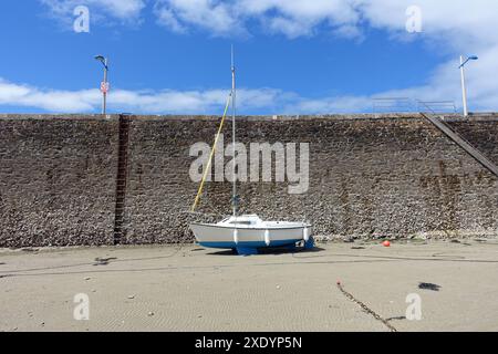 Voilier à marée basse au bord d’un mur de quai, France, Bretagne, Département côtes-d’Armor, Pléneuf-Val-André Banque D'Images