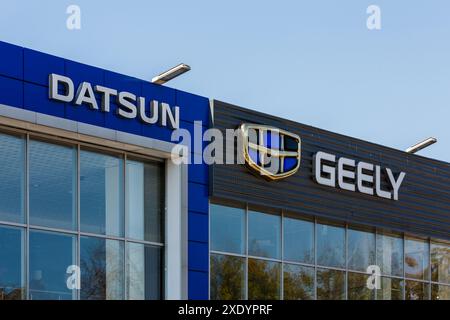 Les logos Datsun et Geely sur les bâtiments de la concession automobile à la journée ensoleillée - Datsun est une marque automobile appartenant à la Nissan Motor Company, Geely est l'un des grands Banque D'Images