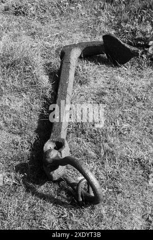 Image en noir et blanc de l'ancre brisée couchée dans l'herbe sur la baie de l'île Sainte de Lindisfarne en reconnaissance de la flotte historique de bateaux de hareng Banque D'Images