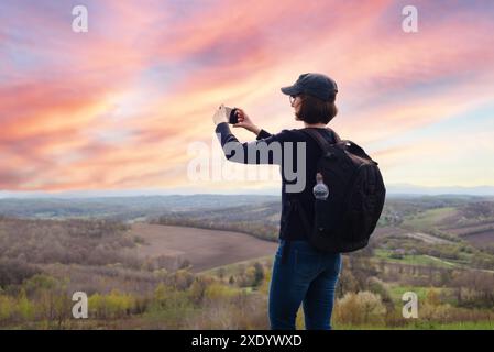 Le modèle féminin d'âge moyen fait la photo des montagnes sur le smartphone Banque D'Images