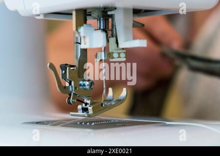 Gros plan sur les pièces de la machine à coudre - pied et aiguille. Mise au point sélective Banque D'Images