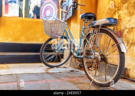 Vélo garé près du mur de la vieille maison sur la rue étroite pittoresque de Hoi an Ancient Town (Hoian), Vietnam. Banque D'Images
