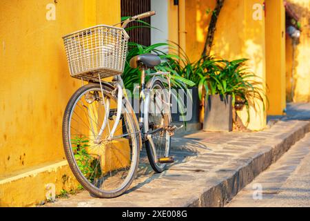 Vélo garé près du mur de la vieille maison sur la rue étroite pittoresque de Hoi an Ancient Town (Hoian), Vietnam. Banque D'Images